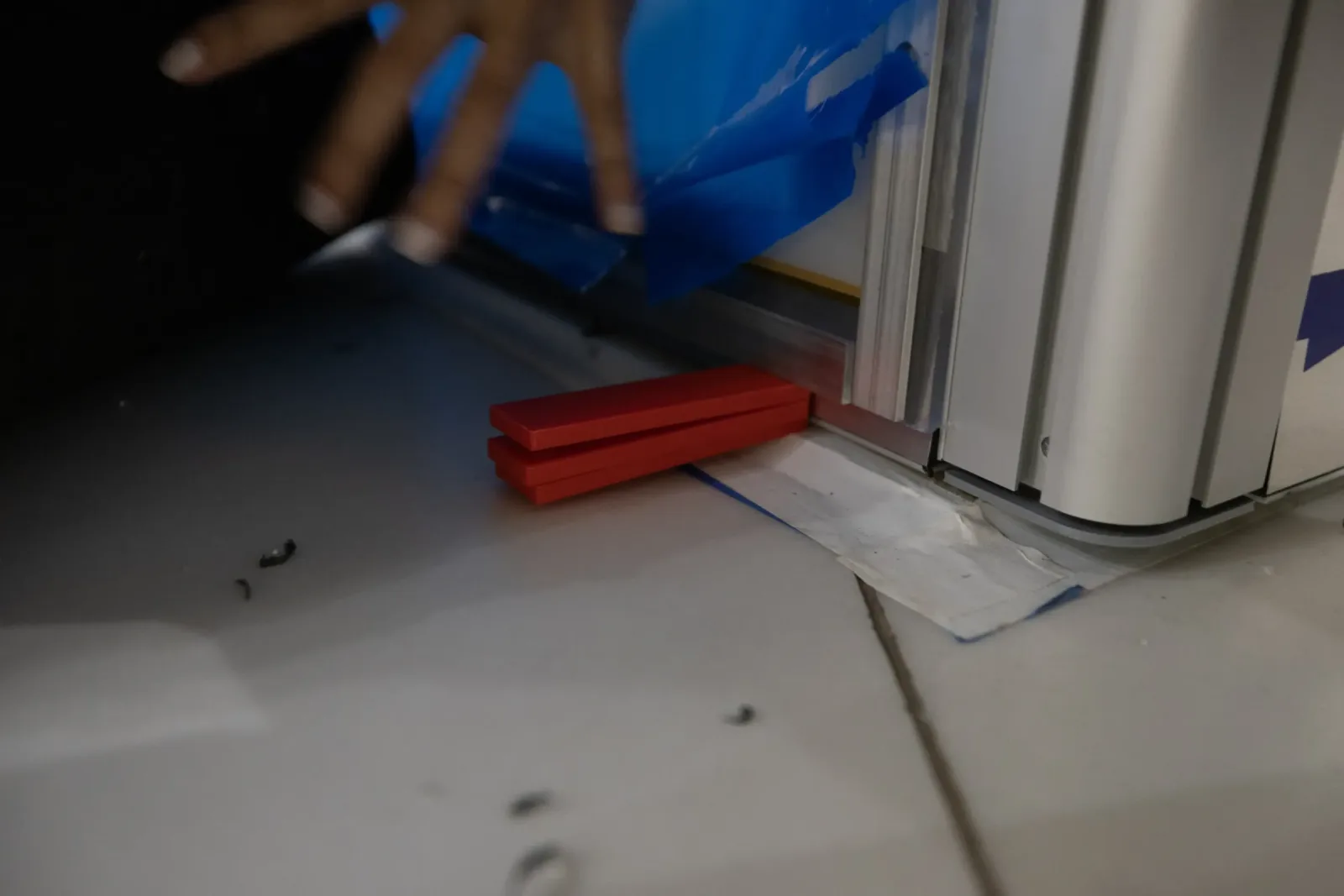 Included red shims hold a Smart Plexi® panel up and level while it adheres